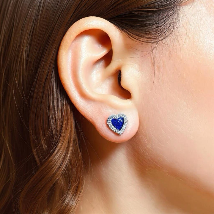 Model is wearing Memorial Ashes CZ heart earrings in sapphire blue