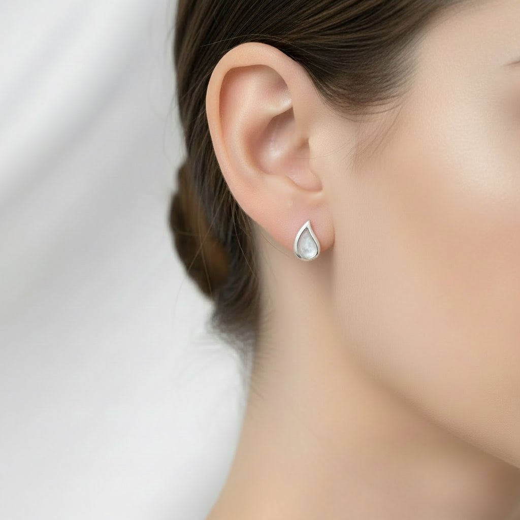 Model wearing tiny droplet earrings made with cremation ashes