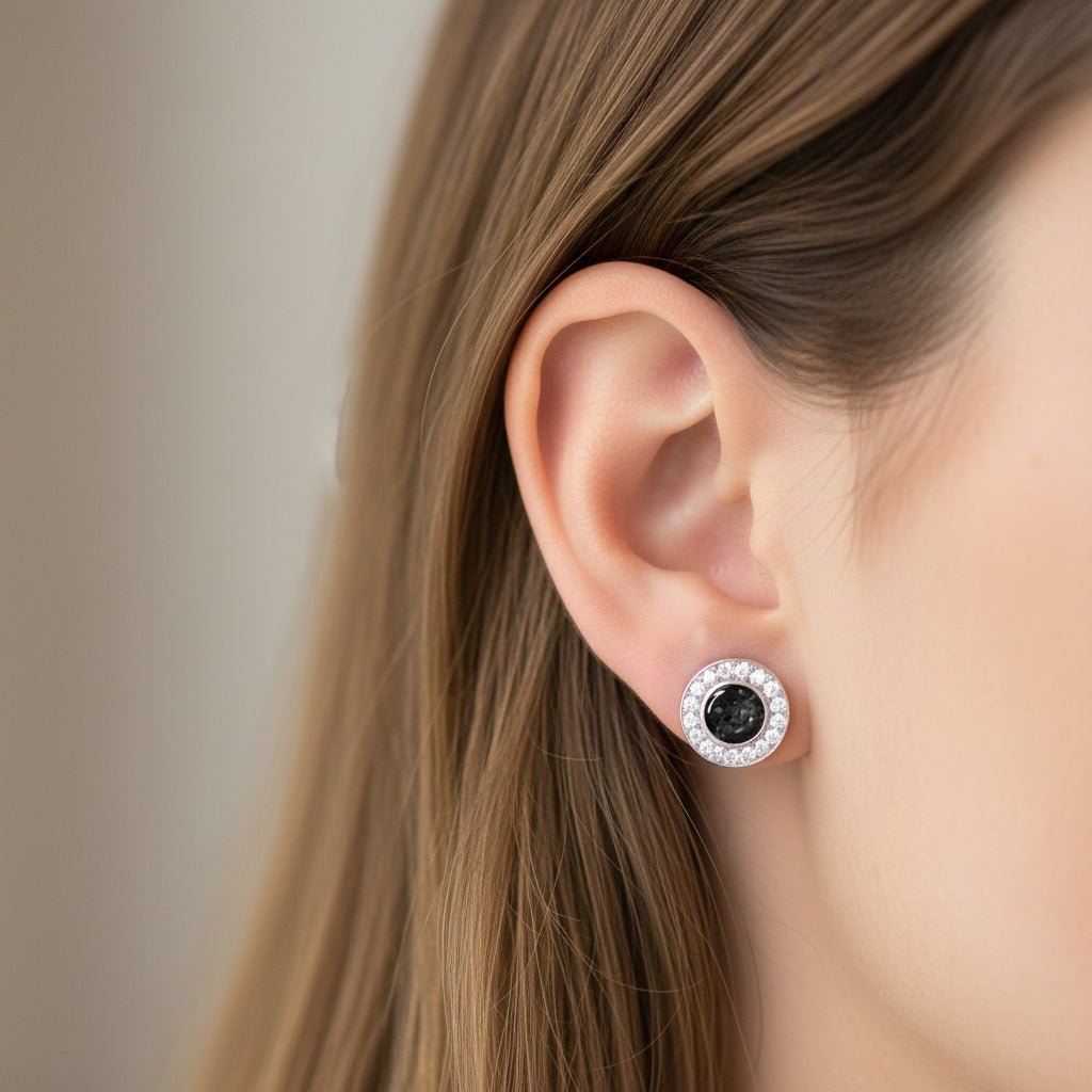 Model wears round crystal halo ashes earrings In black resin. Earrings also available in other colour options.