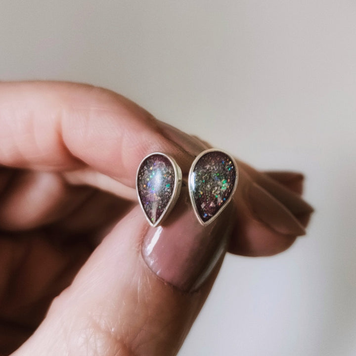 Model holding teardrop ashes earrings to display