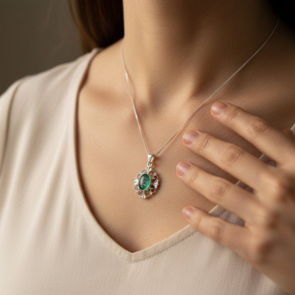 Elegance Memorial Ashes Necklace worn by model around the neck with hand gently touching chest - Nicky Robin Memorial Jewellery